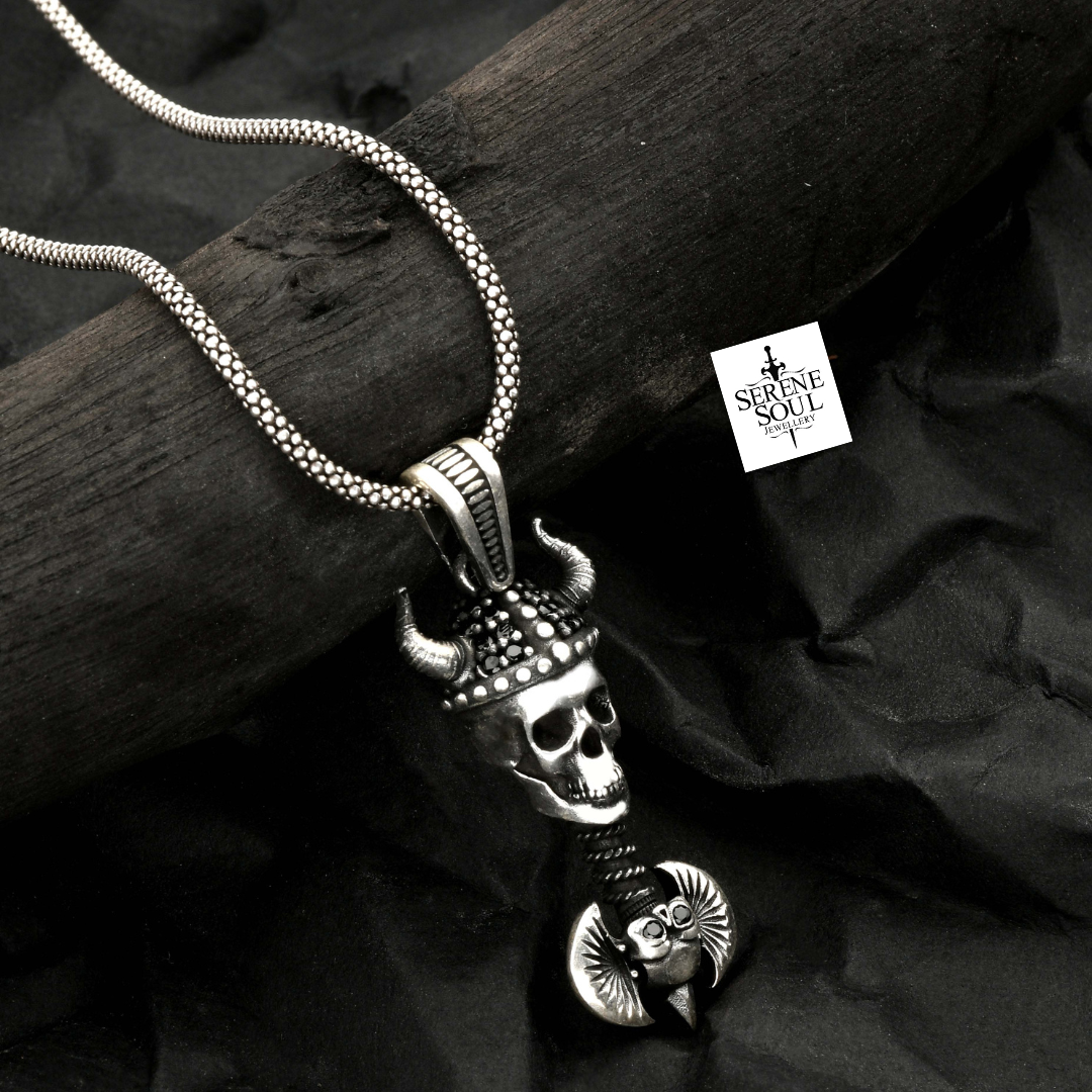 Silver skull pendant necklace on a dark surface with 'Serene Soul' branding.