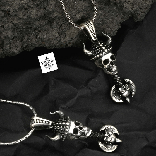 Two silver skull pendants on a dark fabric background with 'Serene Soul' branding.