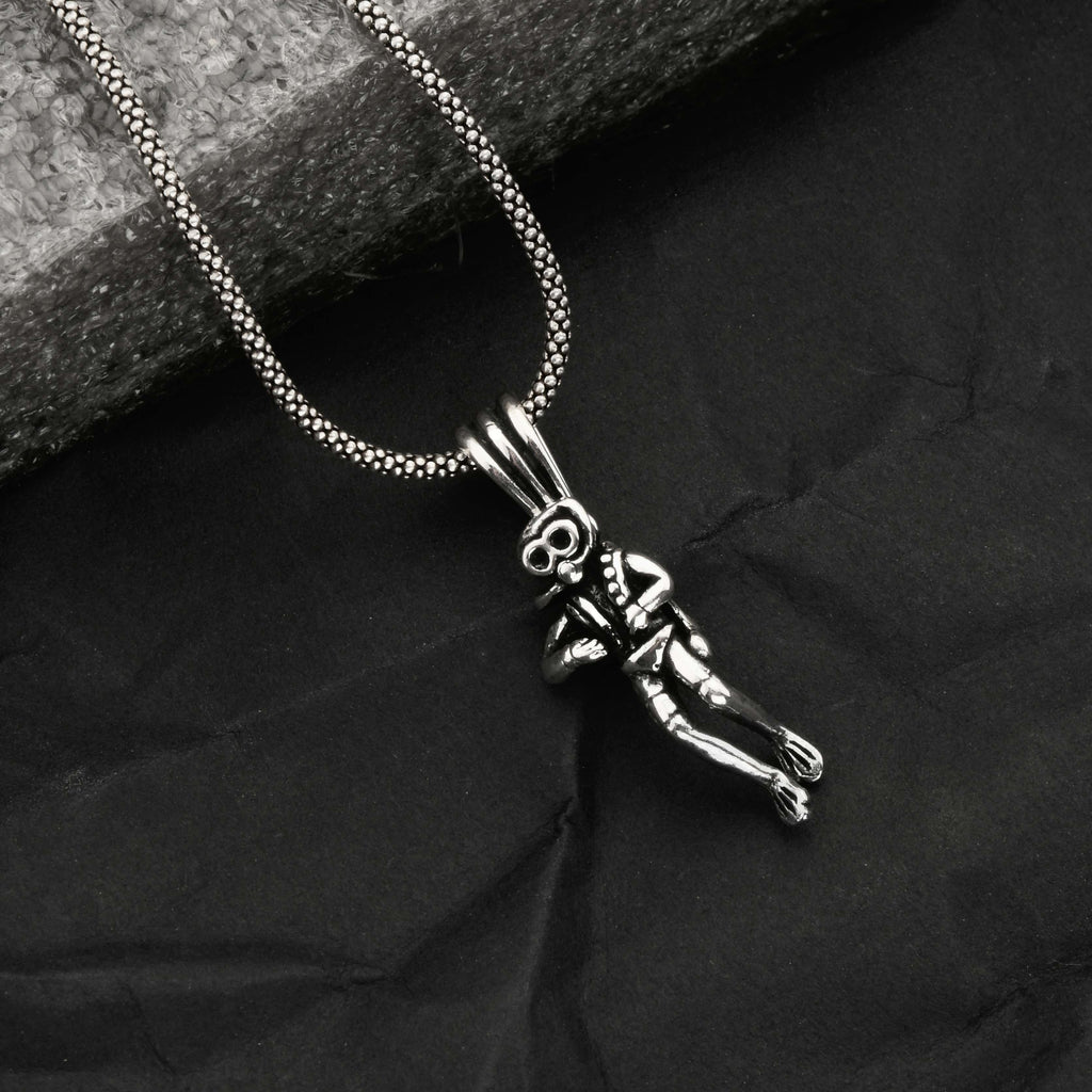 Silver necklace with a pendant on a dark fabric background