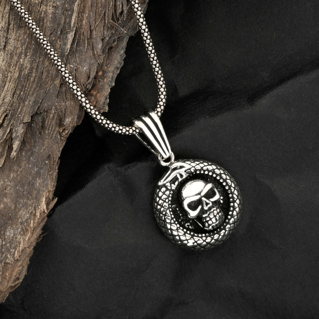 Silver necklace with skull pendant on a dark fabric background