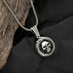 Silver necklace with skull pendant on a dark fabric background
