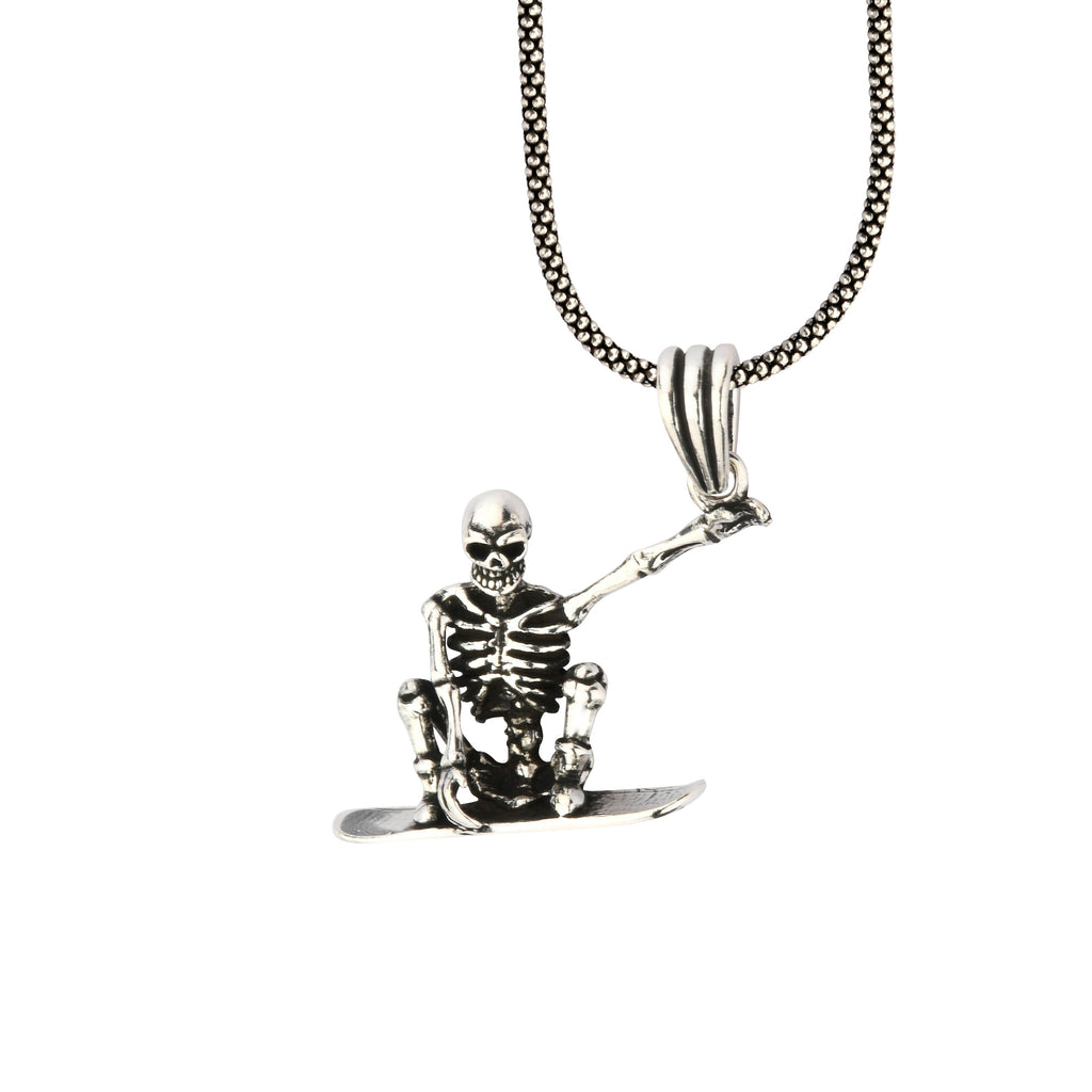 Skeleton pendant on a chain against a white background