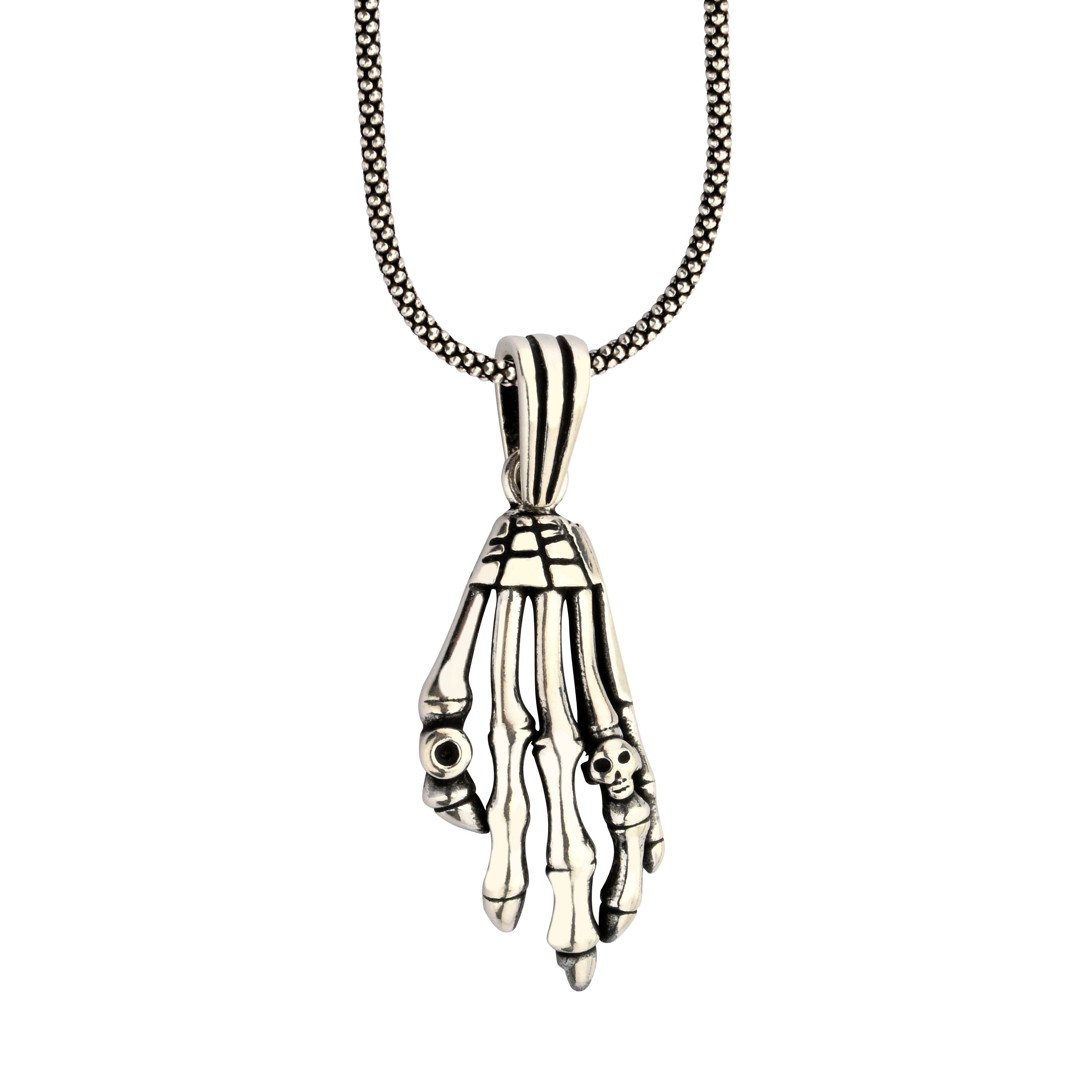 Silver skeleton hand pendant on a chain against a white background