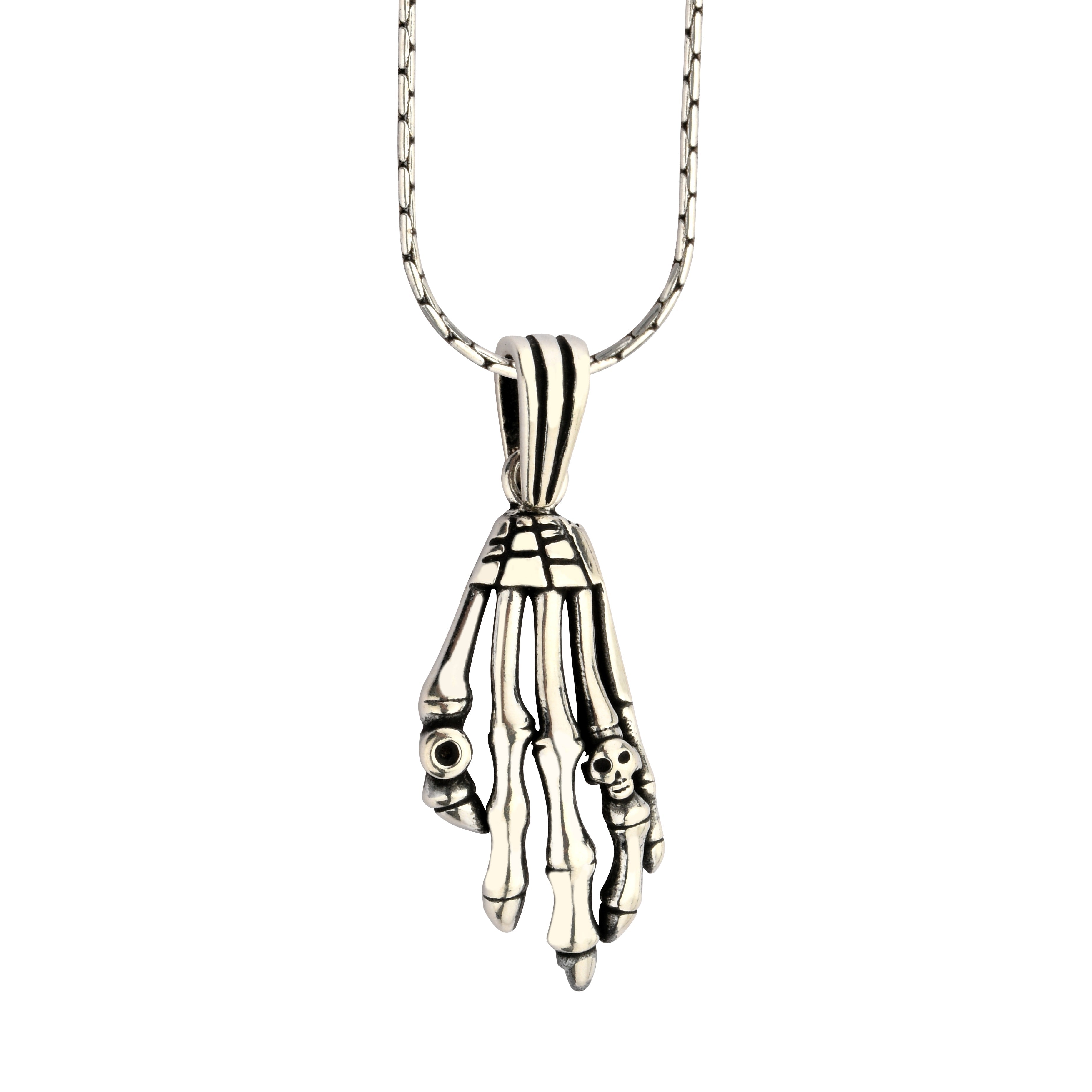 Silver skeleton hand pendant on a chain against a white background